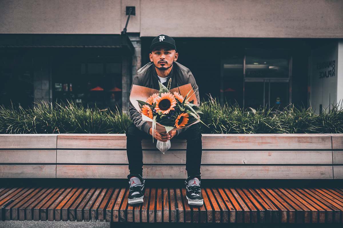 clothing sitting man holding sunflower bouquet shoe