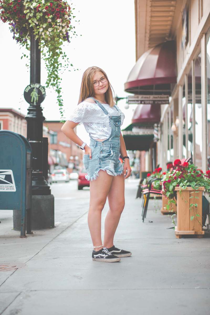 clothing standing woman wearing blue denim romper beside red flowers shorts