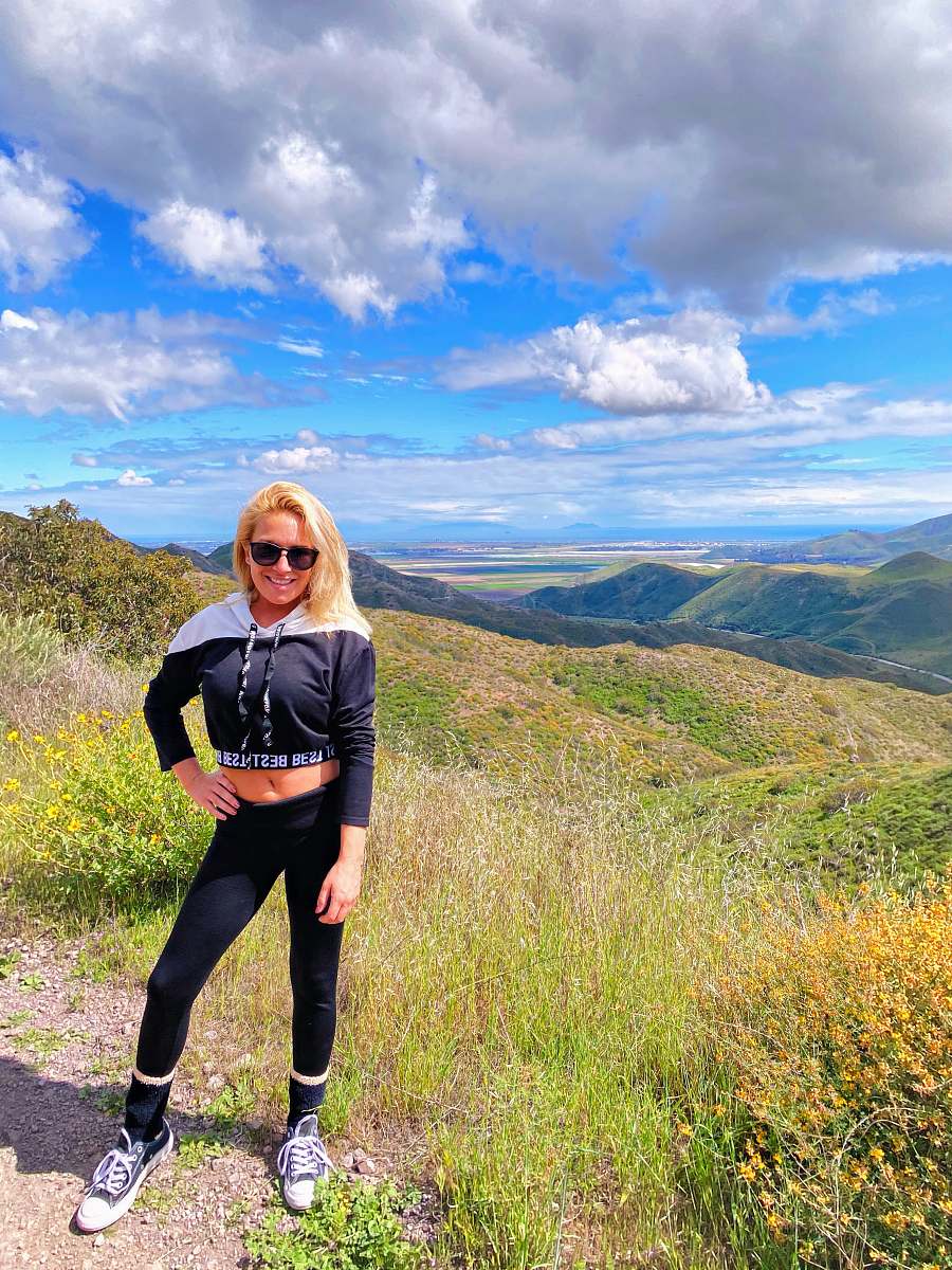 clothing woman in black long sleeve shirt and black pants standing on green grass field during daytime footwear