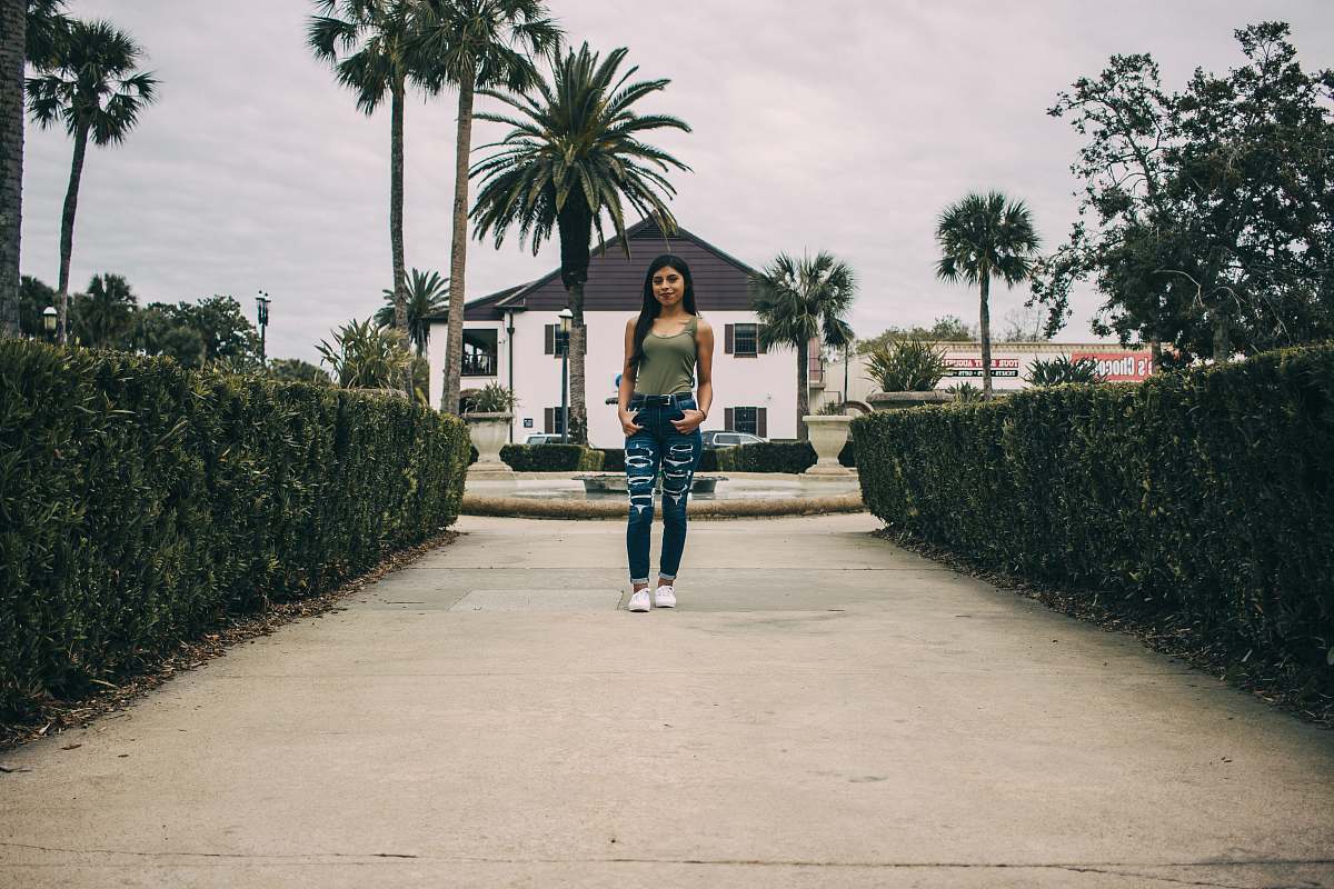 clothing woman standing between hedges footwear