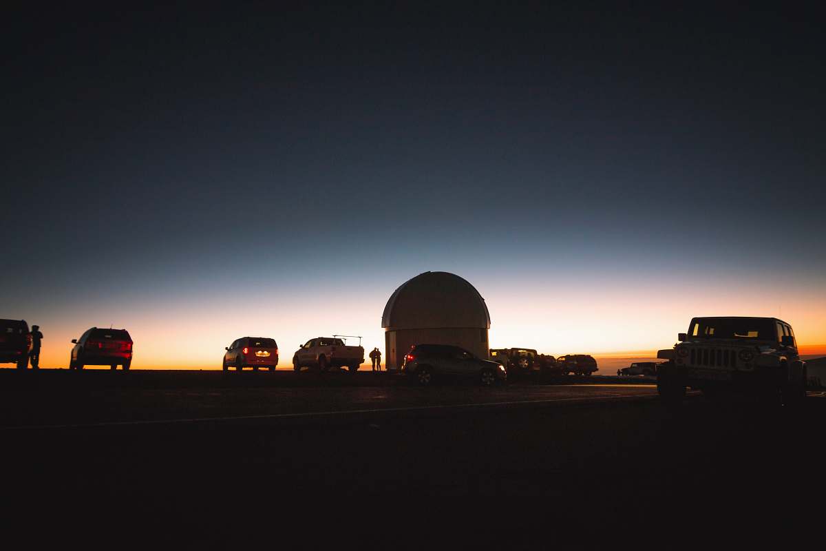 vehicle assorted vehicles parked under gray sky during sunset observatory