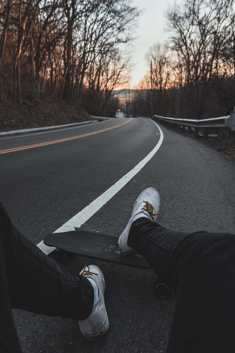 tarmac person sitting on road with longboard cincinnati