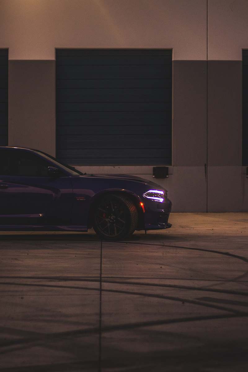car black vehicle parked beside building at nighttime transportation