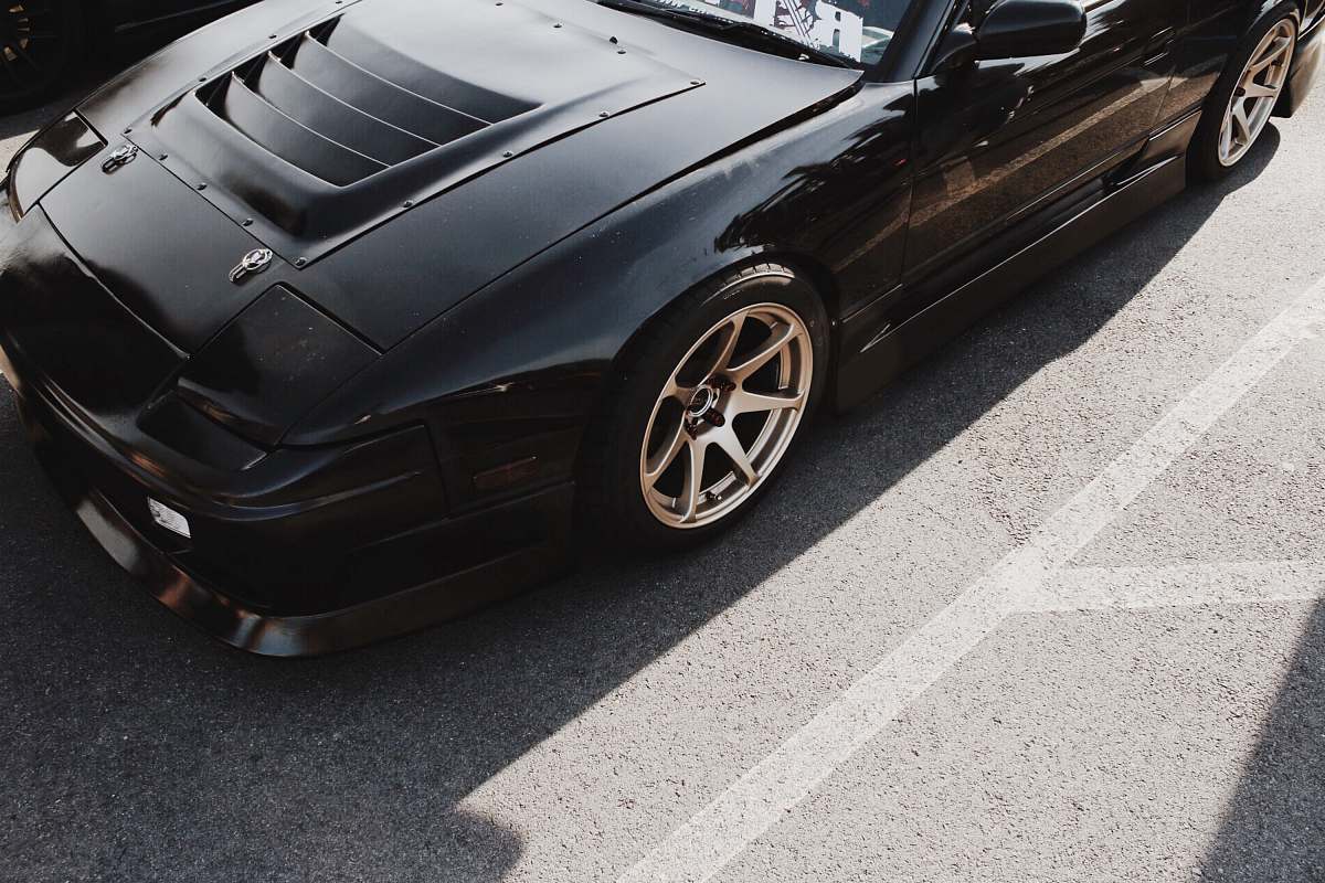 car photo of black coupe parked on concrete pavement transportation