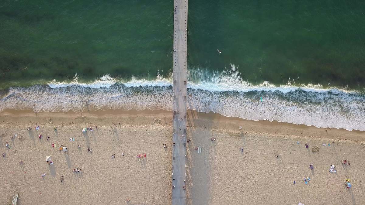coast bird's eye photography of people at beach ocean