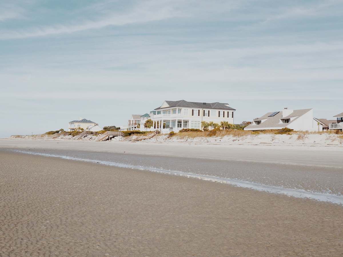 sea white and gray wooden house near road ocean