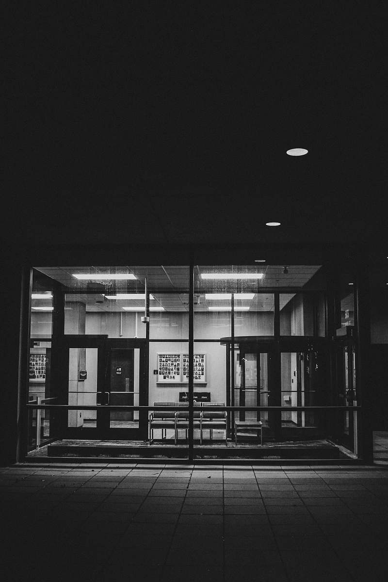 lighting grayscale photo of glass window corridor