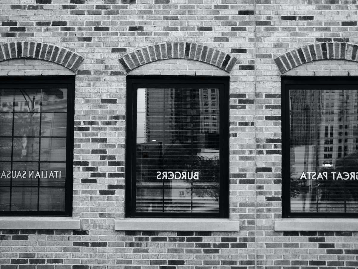 brick grayscale photography of building with glass windows chicago