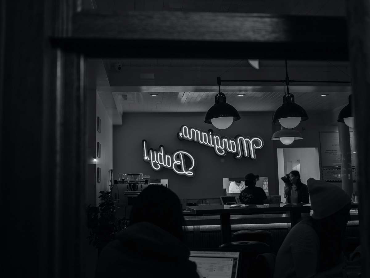 human grayscale photography of Margiamo Baby! neon sign person