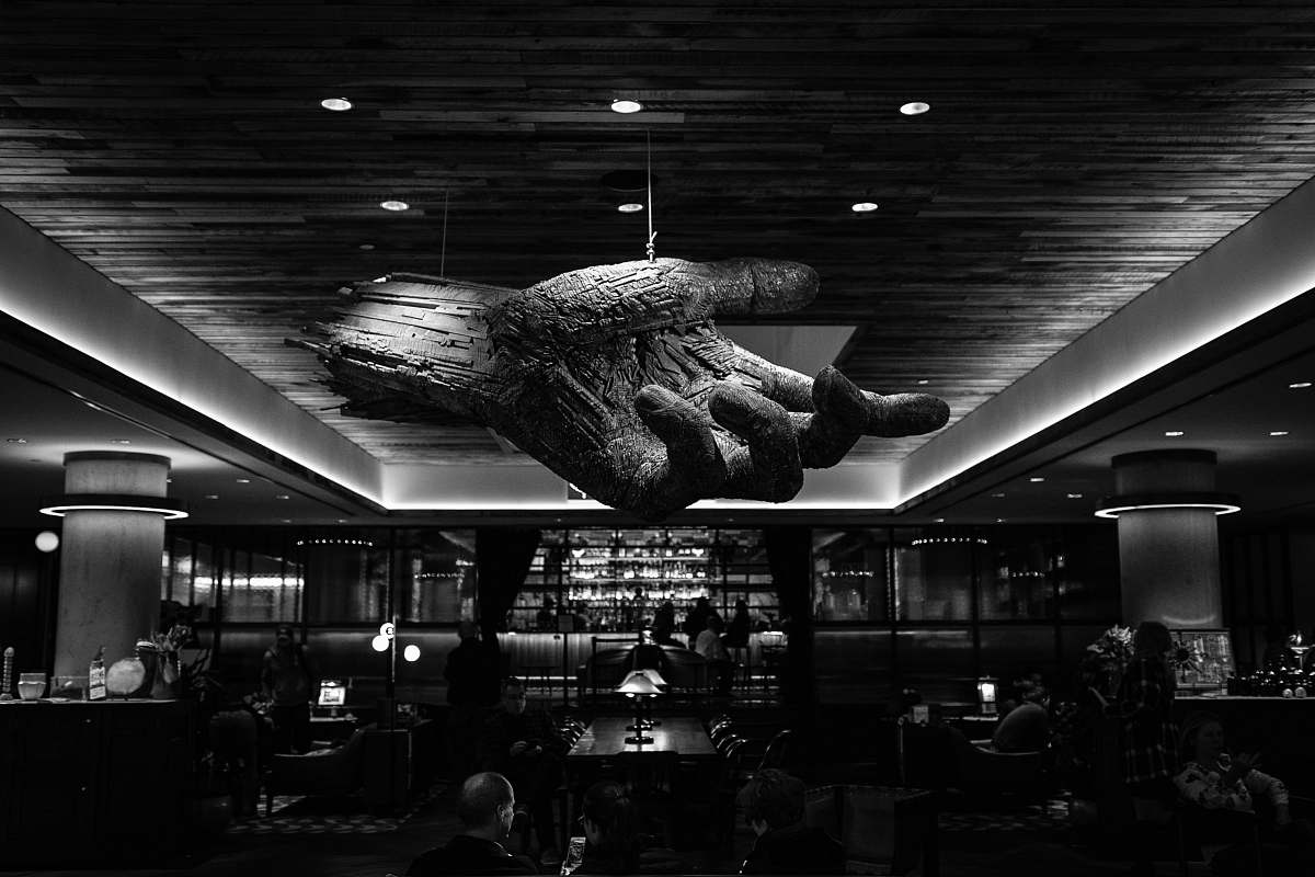 human grayscale photography of restaurant with 3D hand ceiling person