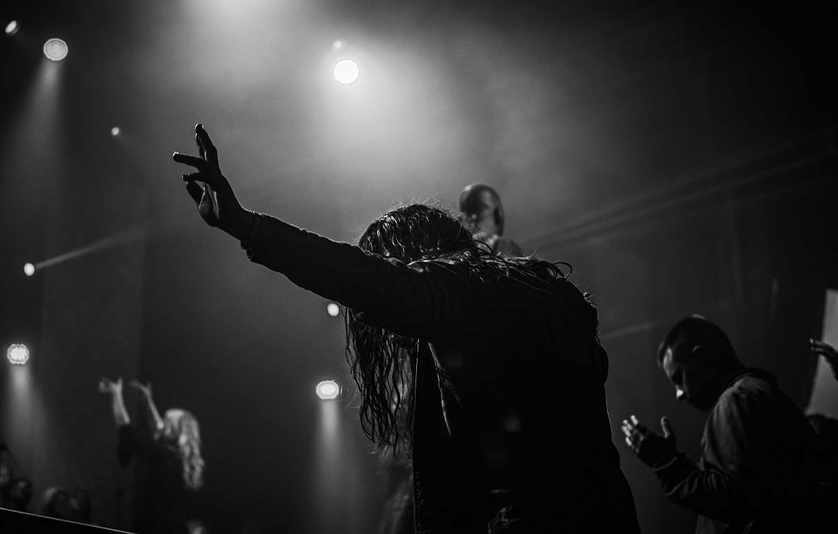 human man in black jacket raising his hand person