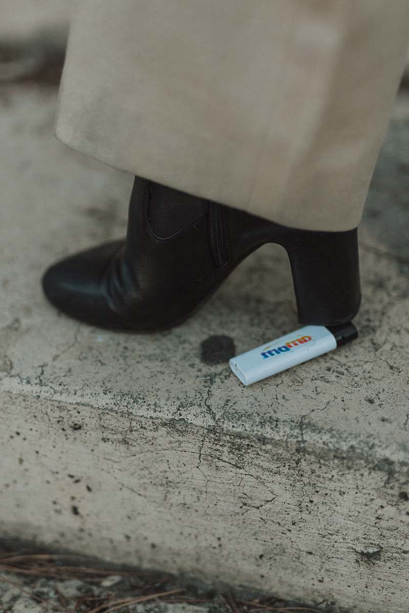 footwear person stepping on white disposable lighter clothing