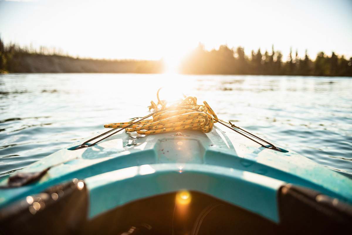 kenai blue kayak on body of water during golden hour dinghy