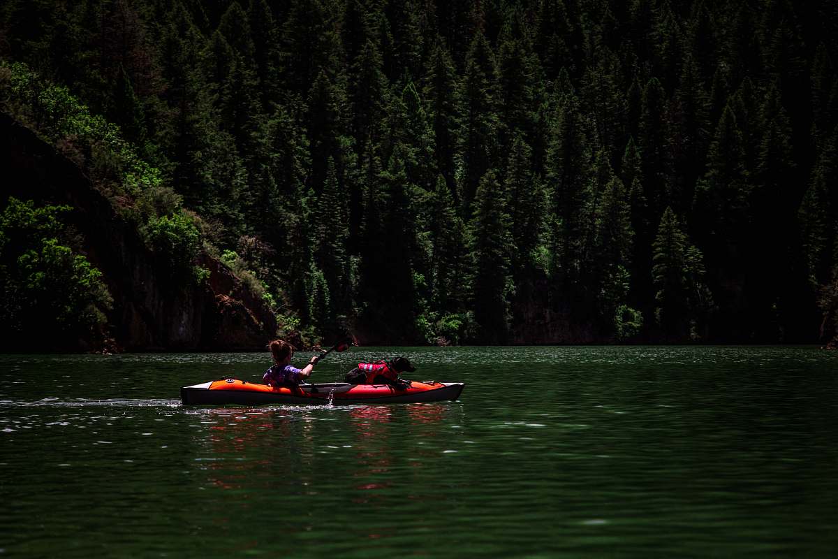 canoe person riding kayak on body of water rowboat