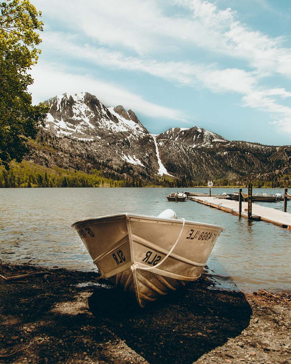 dinghy photo of white boat near body of water at daytime transportation