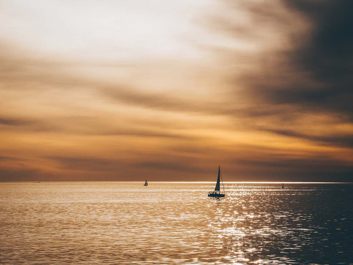 ocean silhouette of sailboat sailing on the ocean sea