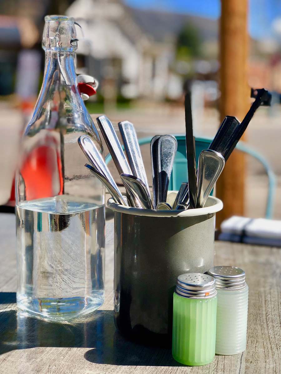 aspen silver-colored cutlery in gray holder with glass bottle on table united states