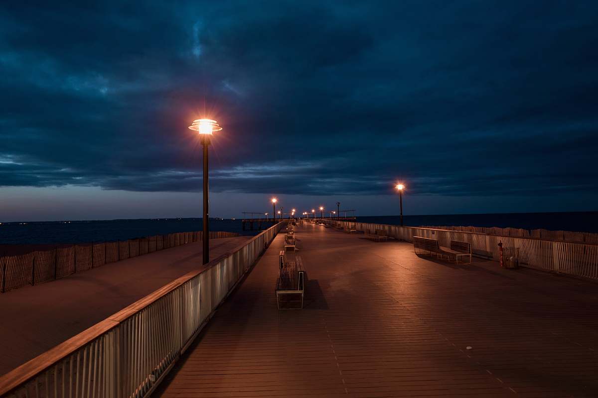 building benches near rail and post lamp boardwalk