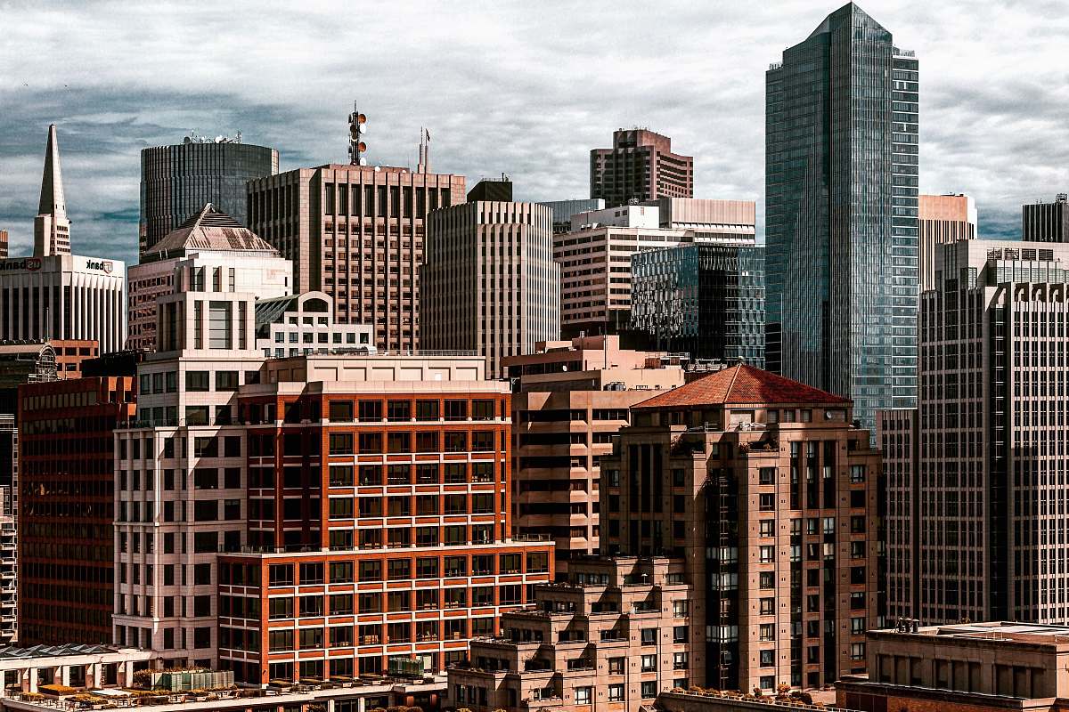 urban brown and gray concrete buildings taken under white clouds during daytime city