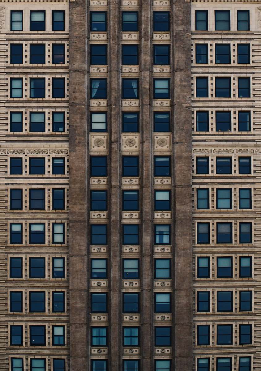 city brown concrete building with blue glass windows during daytime brick
