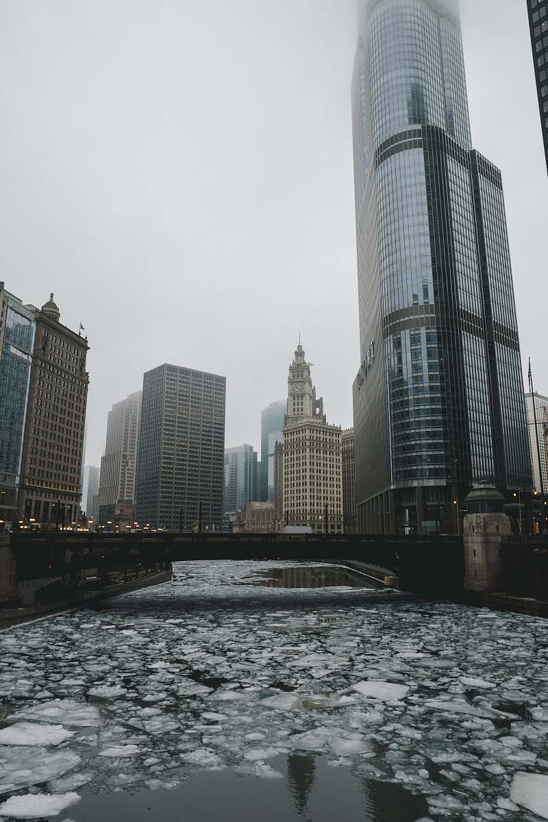 architecture frozen river under bridge photo during foggy daytime skyscraper