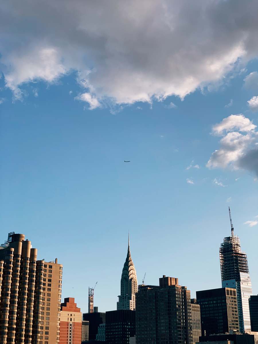 architecture gray and brown buildings under blue skye and gray clouds spire