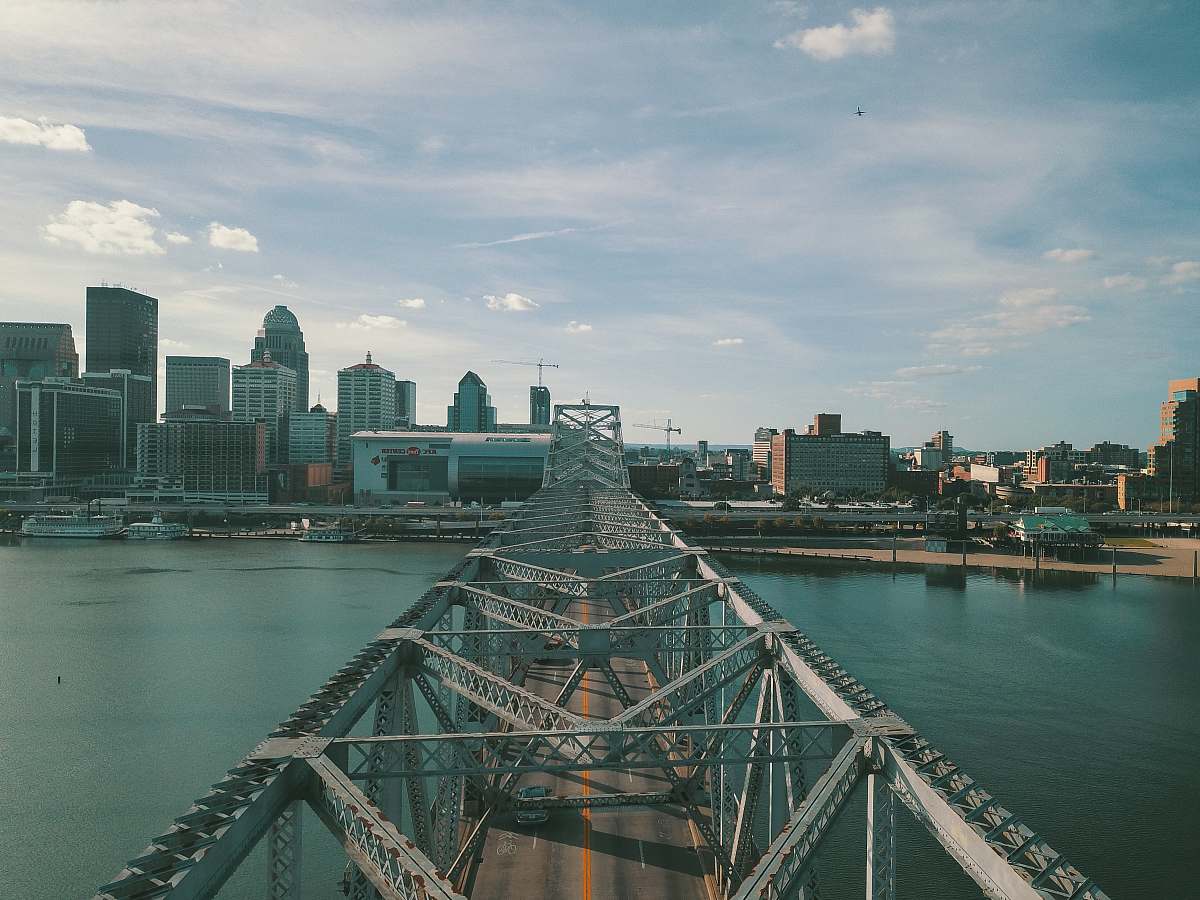 city gray concrete bridge above body of water at daytime grey