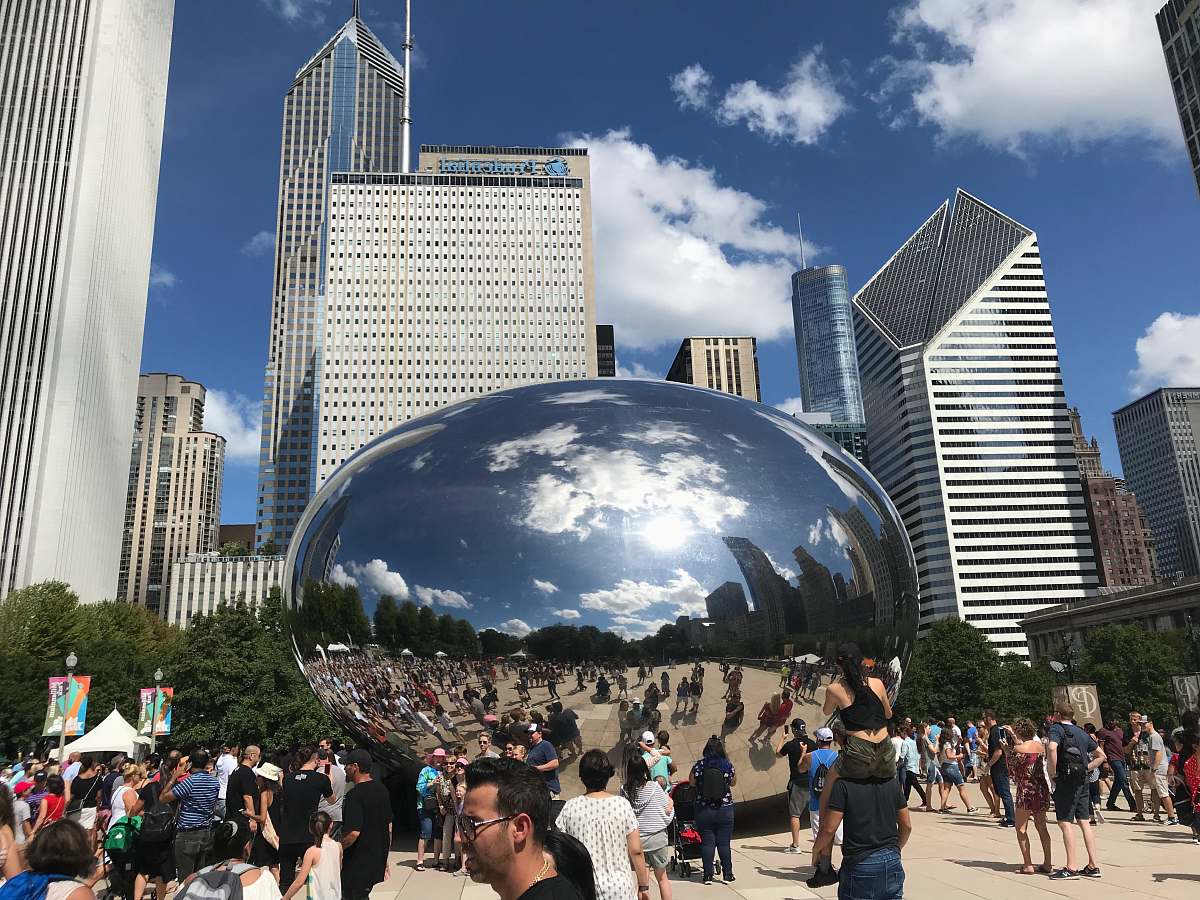 city people walking on park near cloud gate during daytime downtown