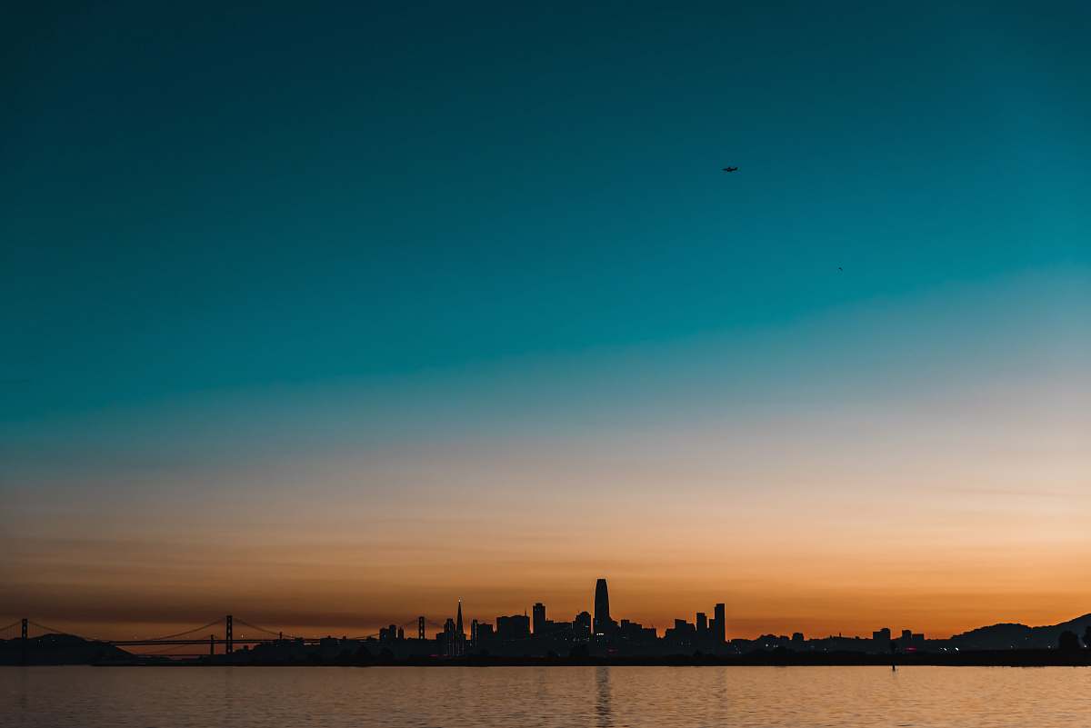 sky silhouette photography of buildings and body of water san francisco