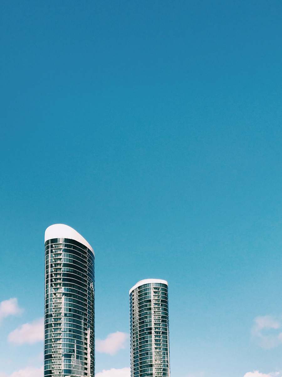 condo white and black high rise building under blue sky during daytime housing