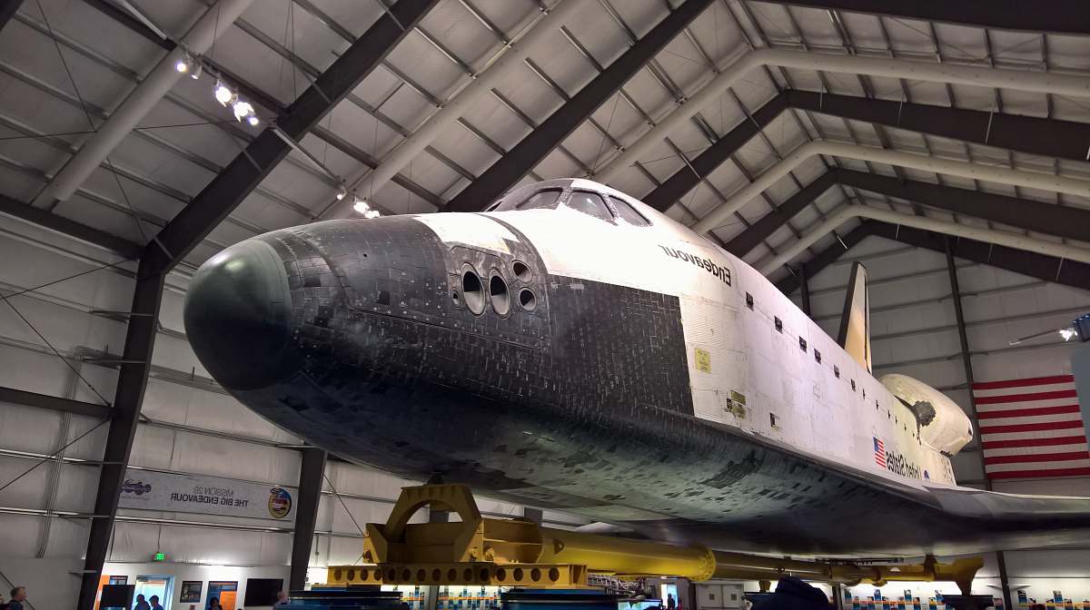 transportation white and gray plane inside gray shed hangar