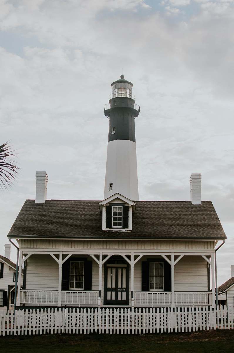 beacon white lighthouse under white sky cottage