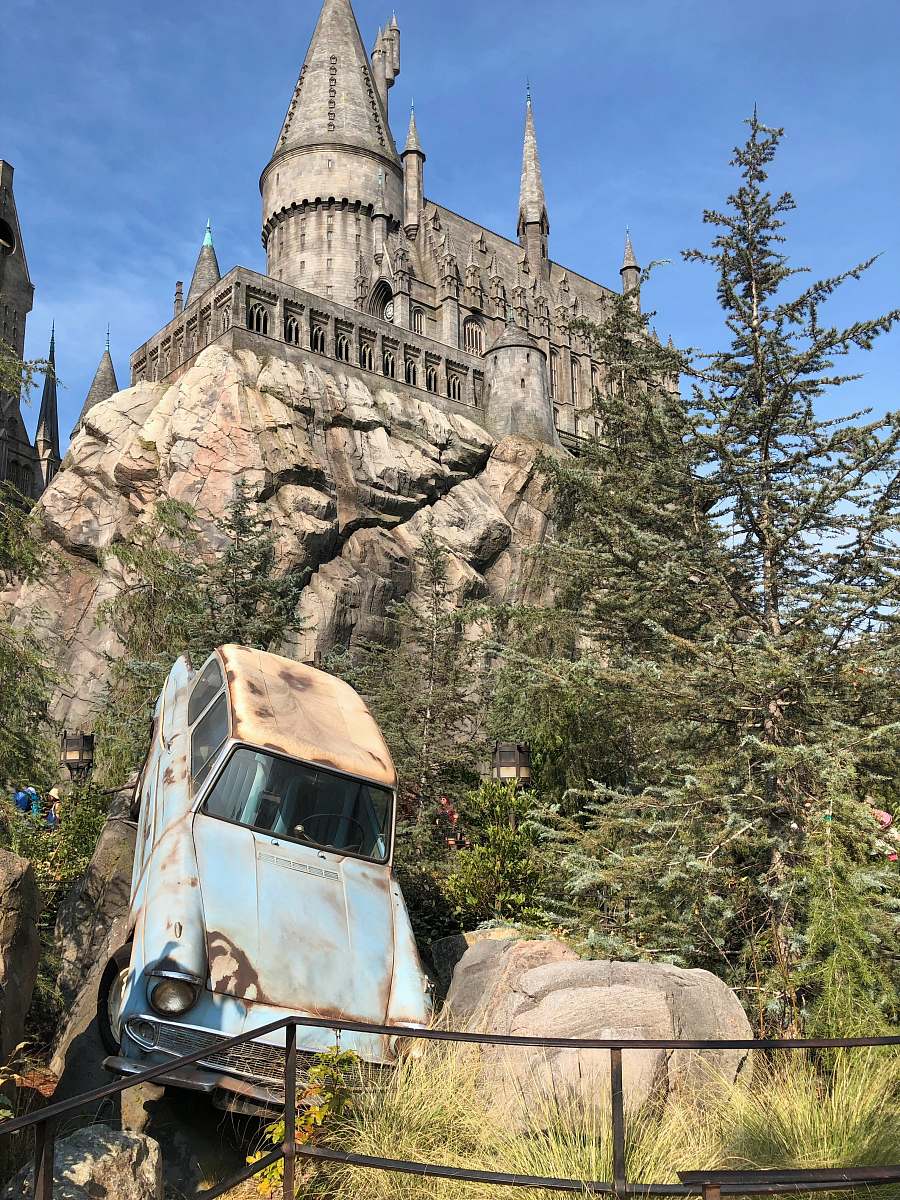 architecture white volkswagen beetle parked near brown concrete building during daytime the wizarding world of harry potter