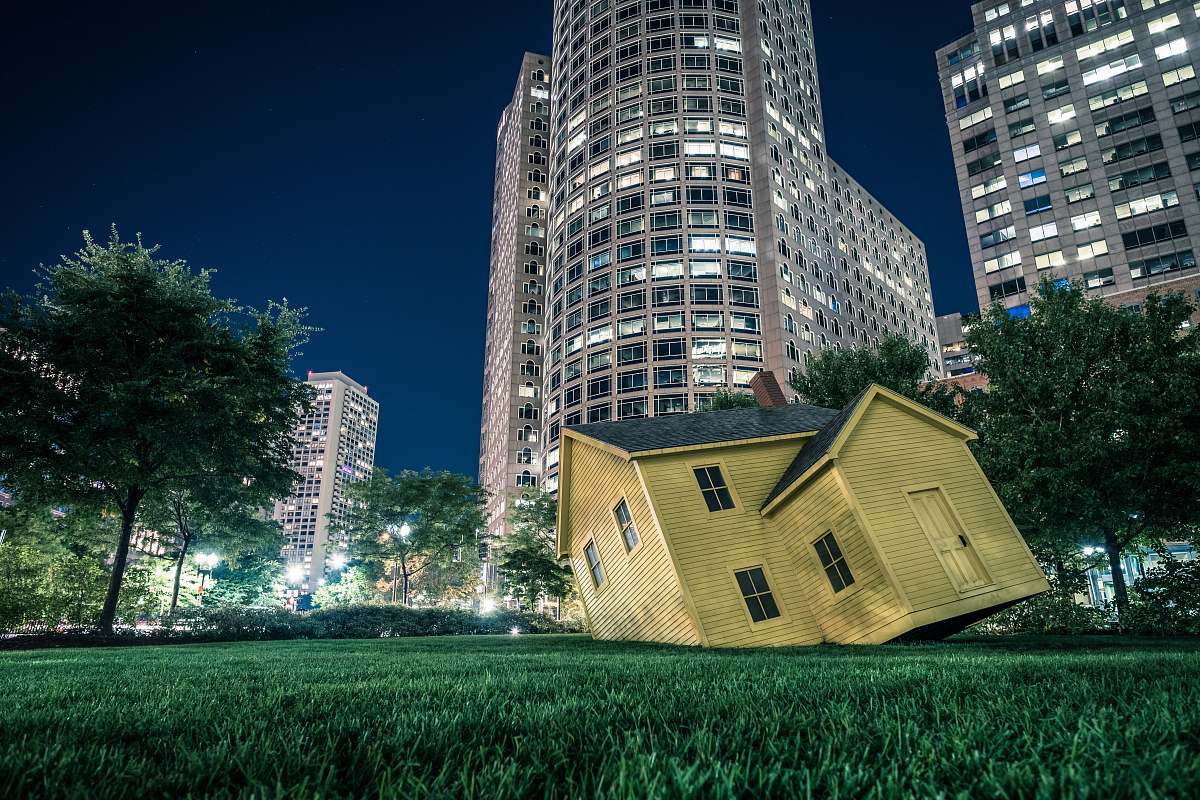 housing yellow house on green grass overlooking buildings at nighttime boston