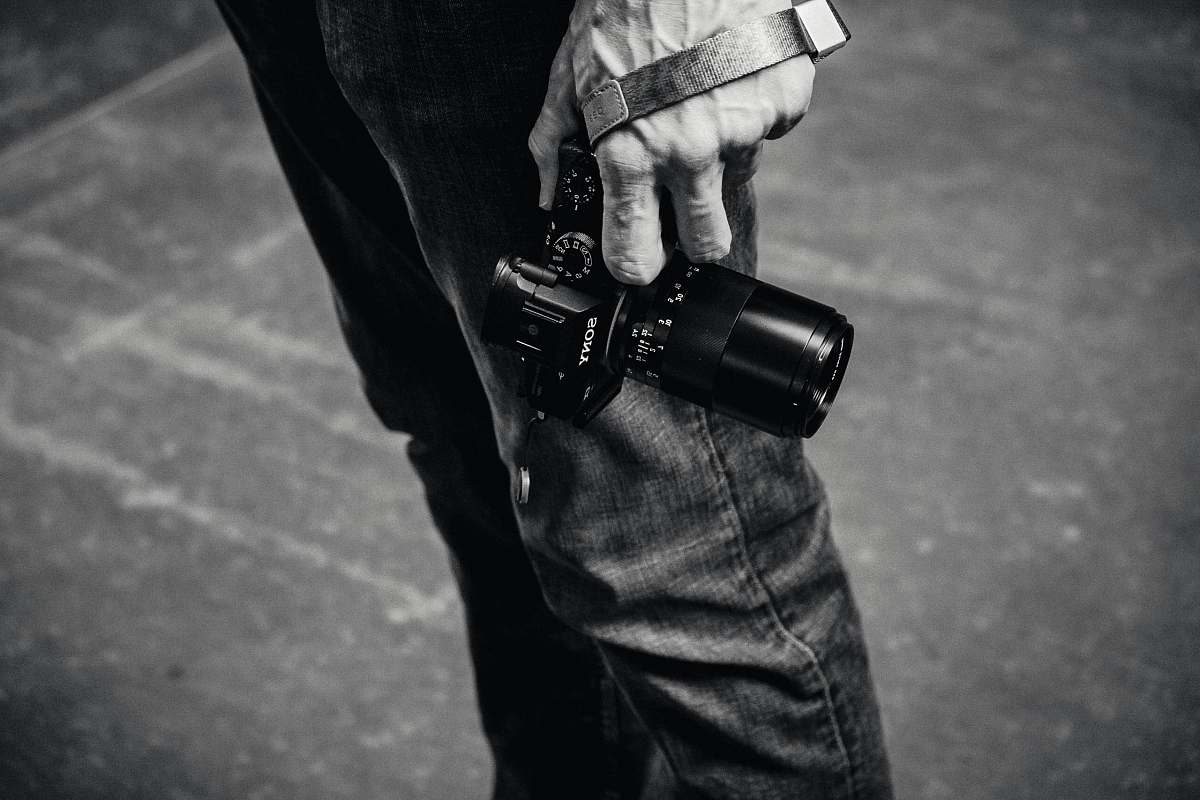 black-and-white grayscale photo of person holding DSLR camera ferry building