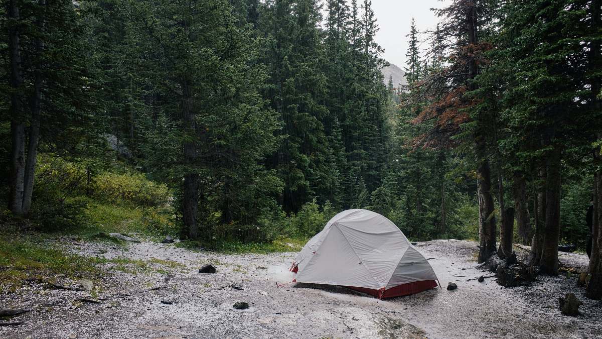 tent gray tent beside lake surrounded by trees leisure activities
