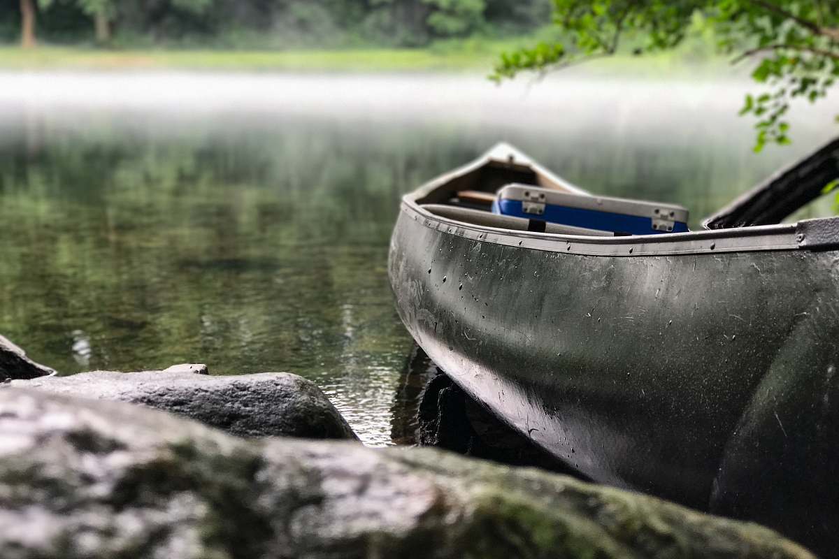 Boat Focus Photo Of Gray And Black Canoe On Body Of Water Under Green ...