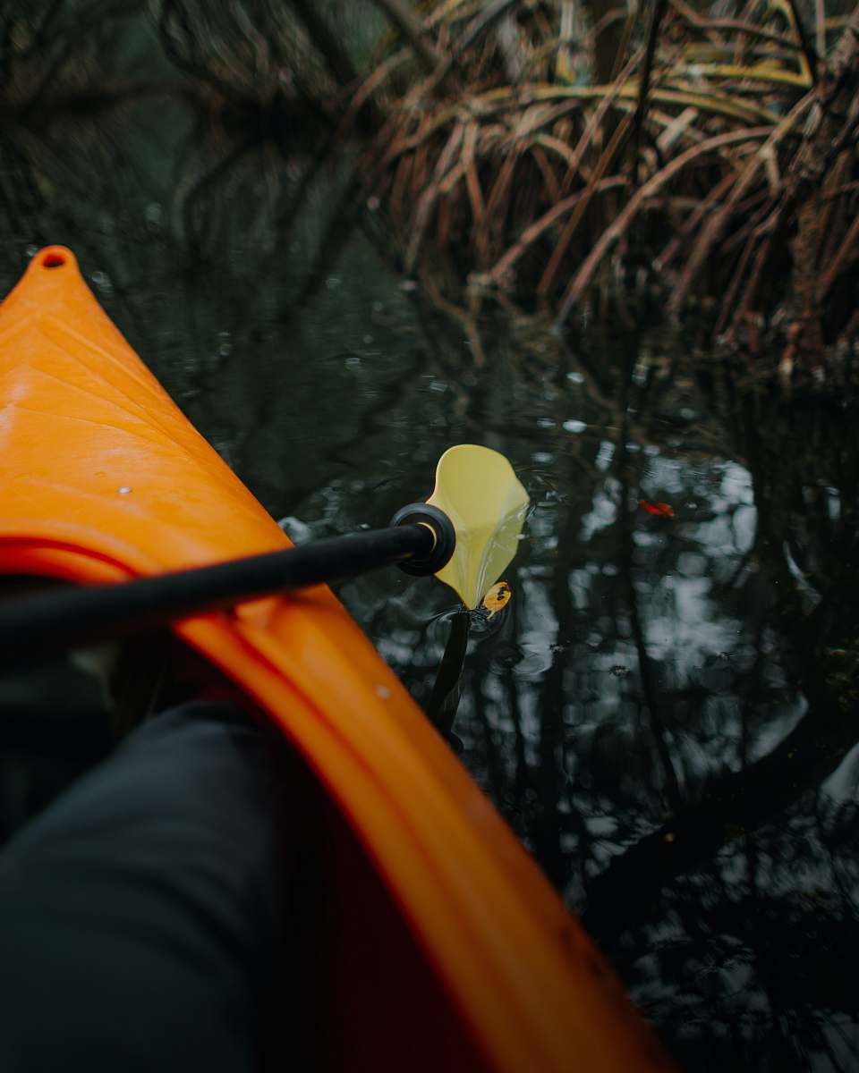 boat person riding orange kayak rowboat