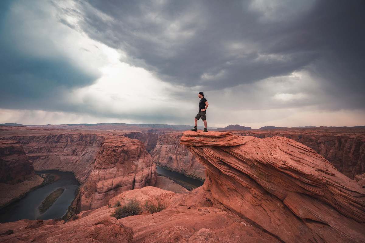 mountain man standing on top of horseshoe bend at Arizona nature
