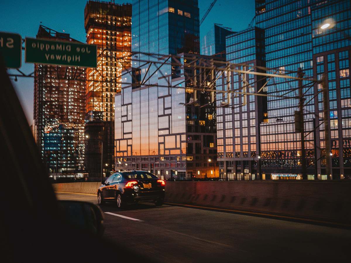 manhattan car passing through road beside building automobile