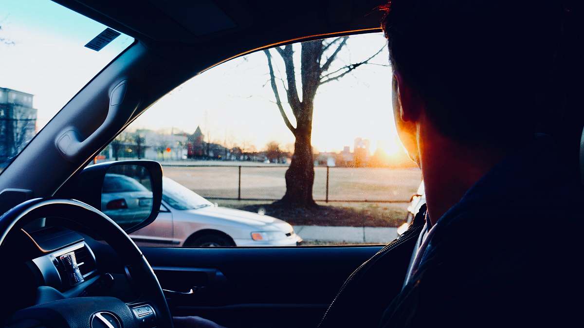 vehicle man sitting inside car looking at sun automobile