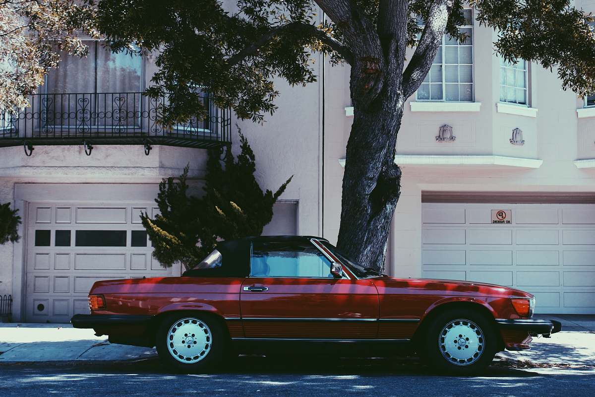 vehicle red Mercedes-Benz SLC 45 parked beside tree pottery