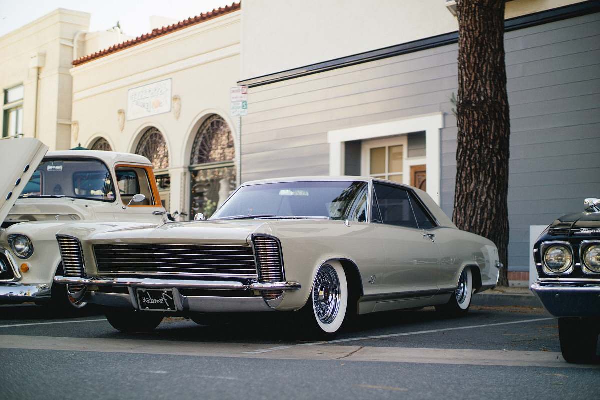 automobile white coupe parked near tree and building coupe
