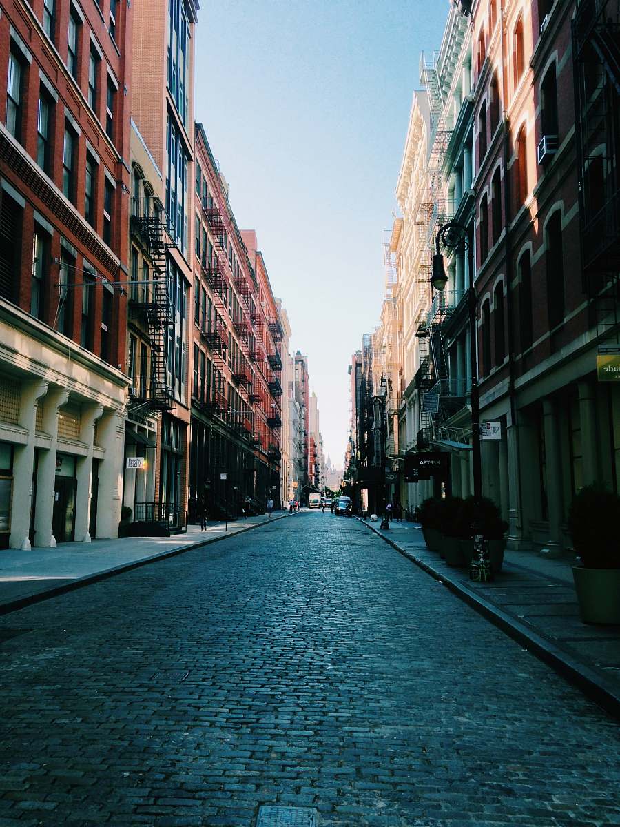 street photo of road between brown buildings building