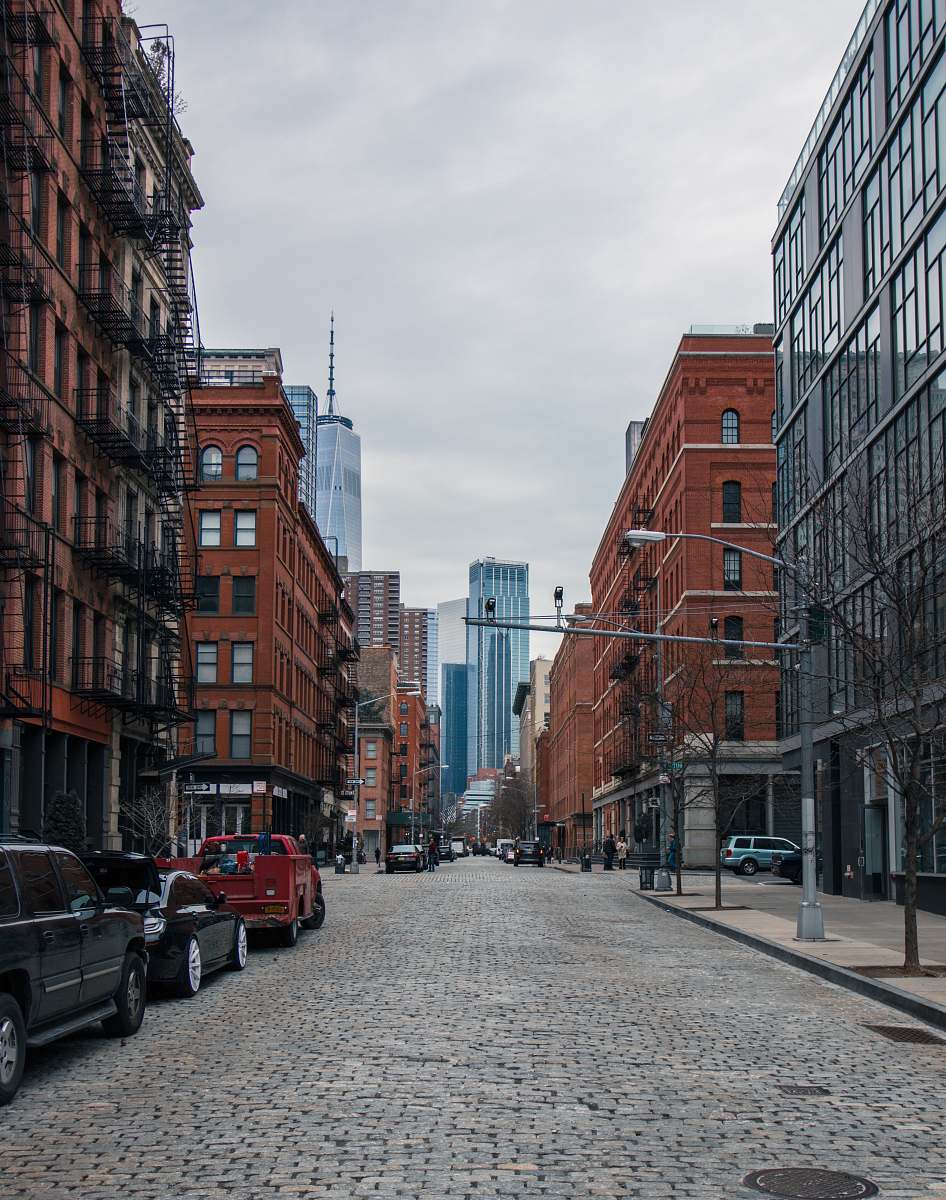 street vehicles on roadway between high rise buildings at daytime tribeca