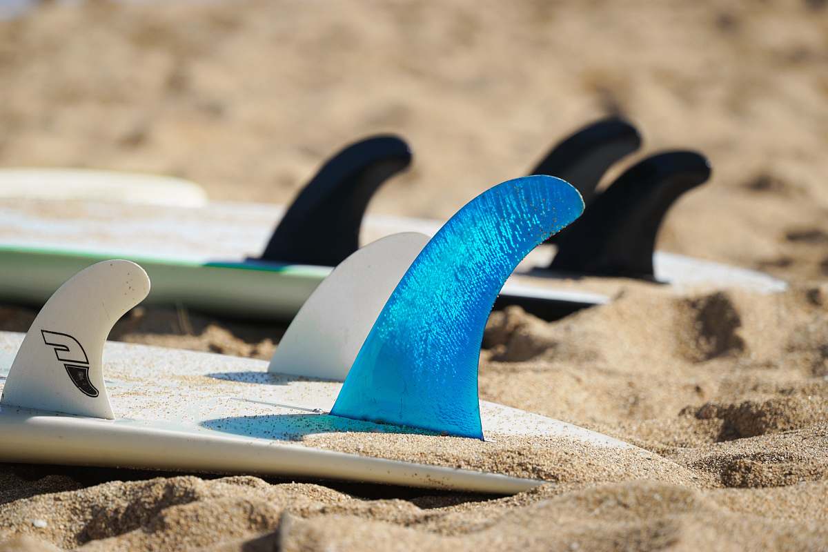 flip-flop closeup photo of two white surfboards on sand footwear