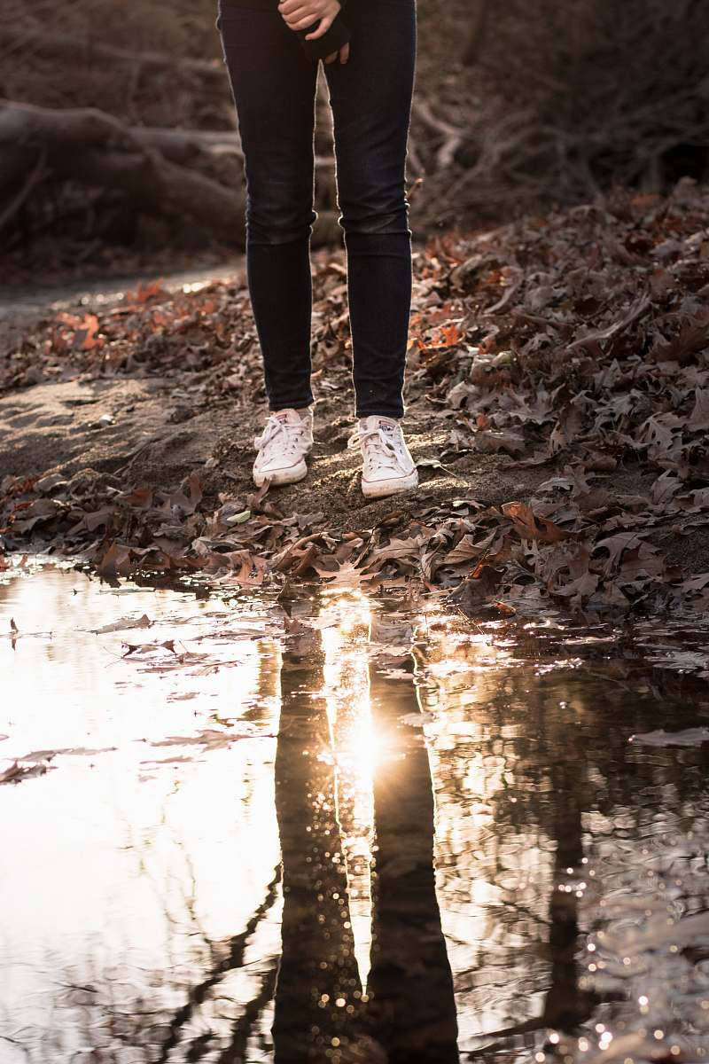 apparel person standing near the body of water wearing black jeans during daytime footwear
