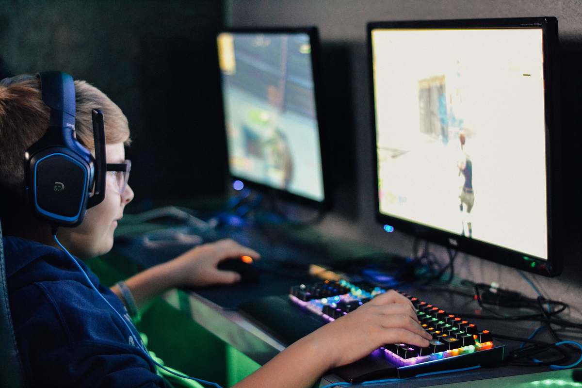 electronics boy wearing headset playing computer game monitor