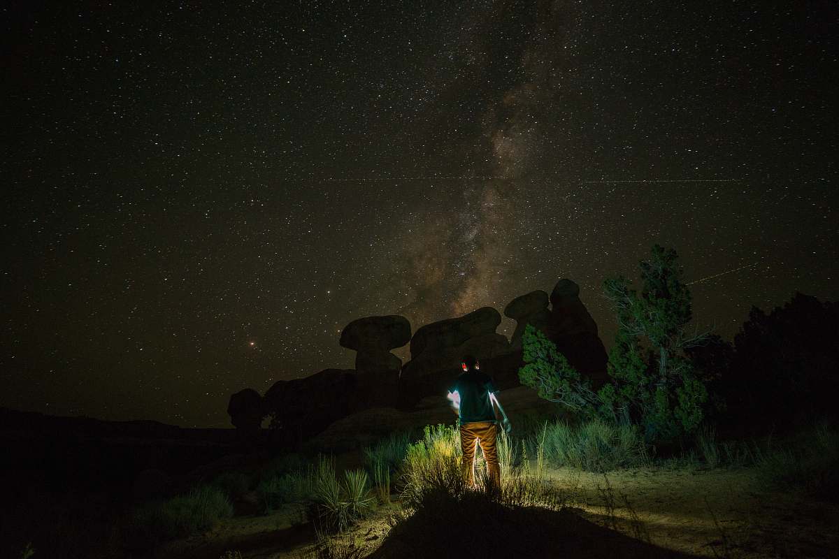 jar person standing near rock formation during night time plant