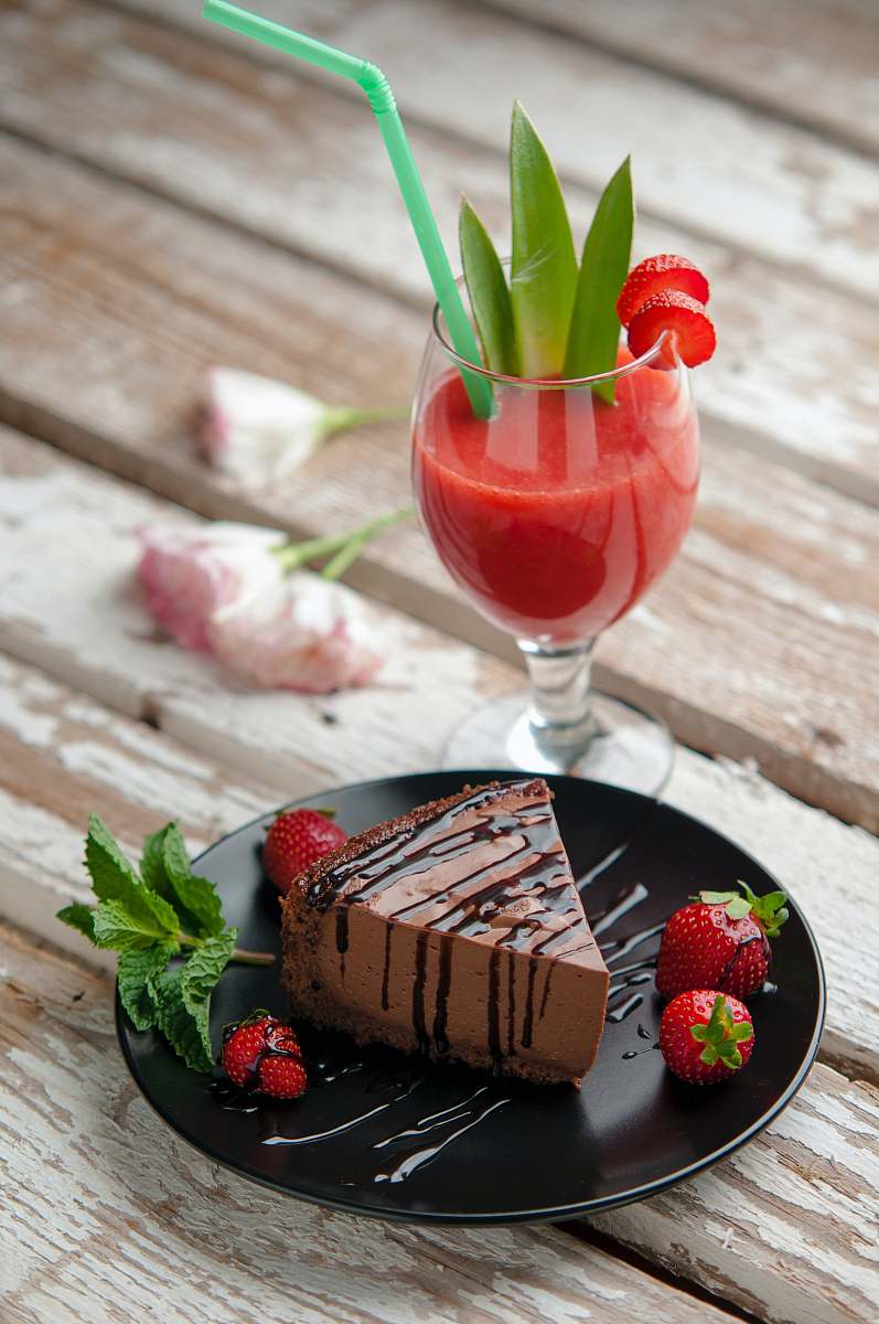 cocktail chocolate cake beside strawberries and wine glass drink